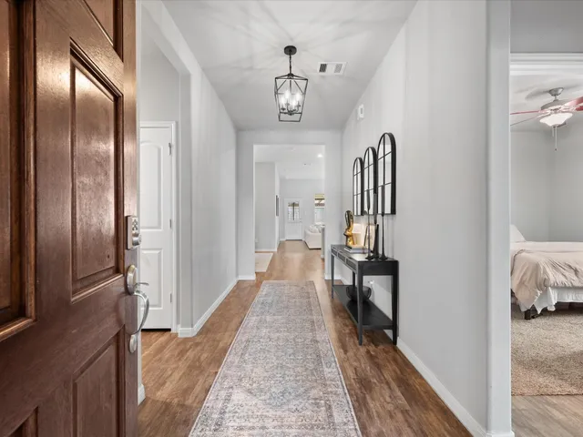 a view of a hallway with a livingroom and furniture