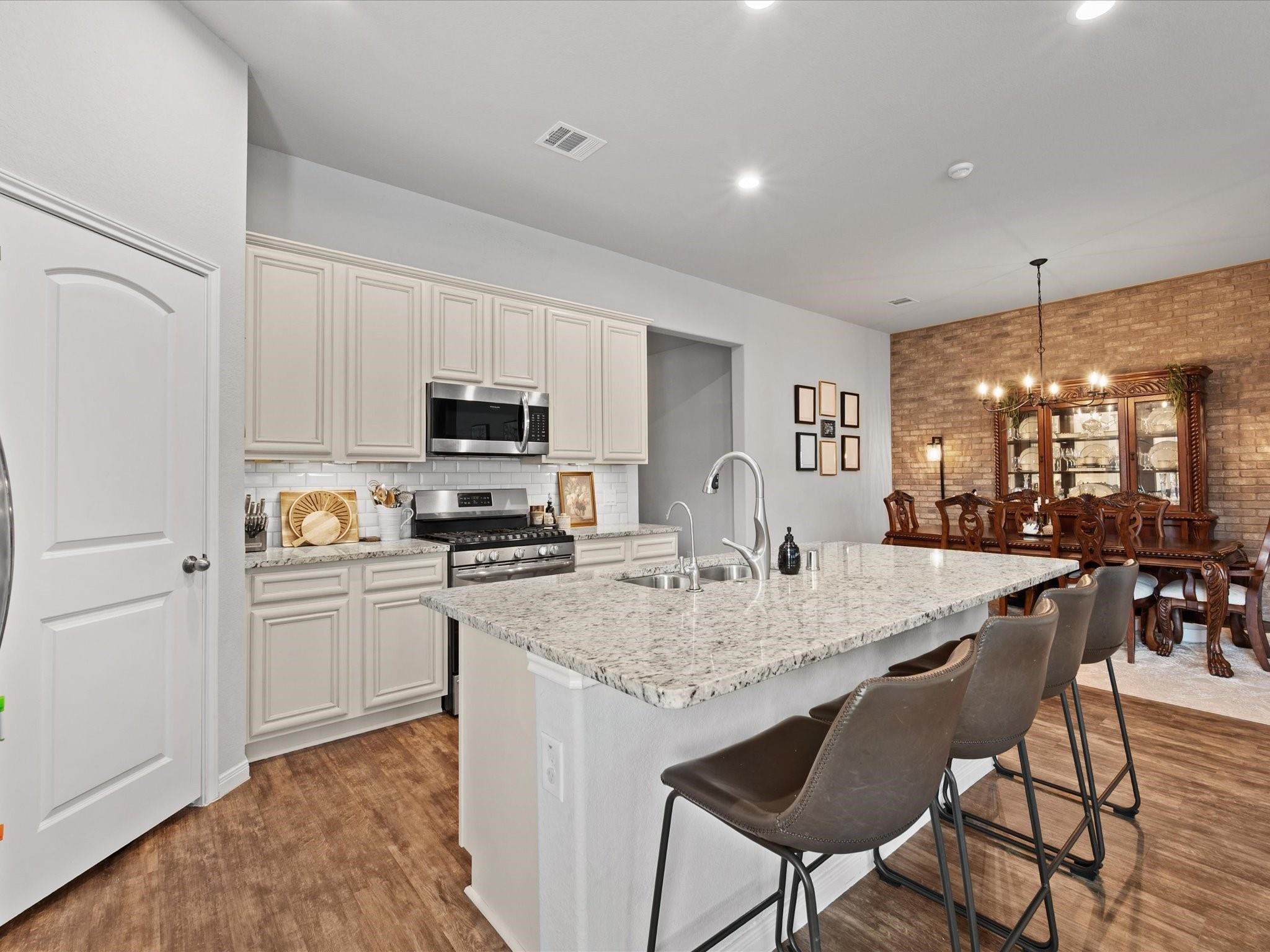 14381 Whitetop Peak Court Conroe, TX 77384 - Photo 7 of 39 a kitchen with granite countertop kitchen island cabinets and refrigerator