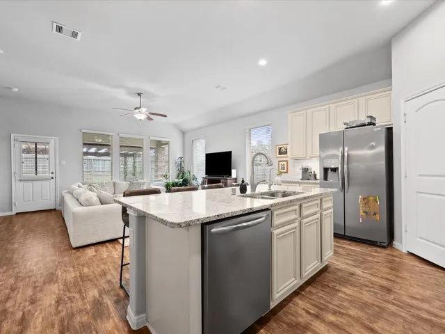 a kitchen with stainless steel appliances granite countertop a sink stove and refrigerator