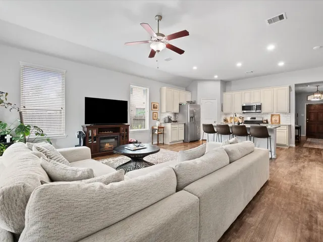 a living room with furniture kitchen view and a flat screen tv