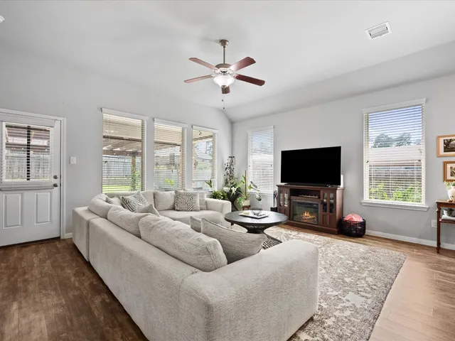a living room with furniture a flat screen tv and a large window