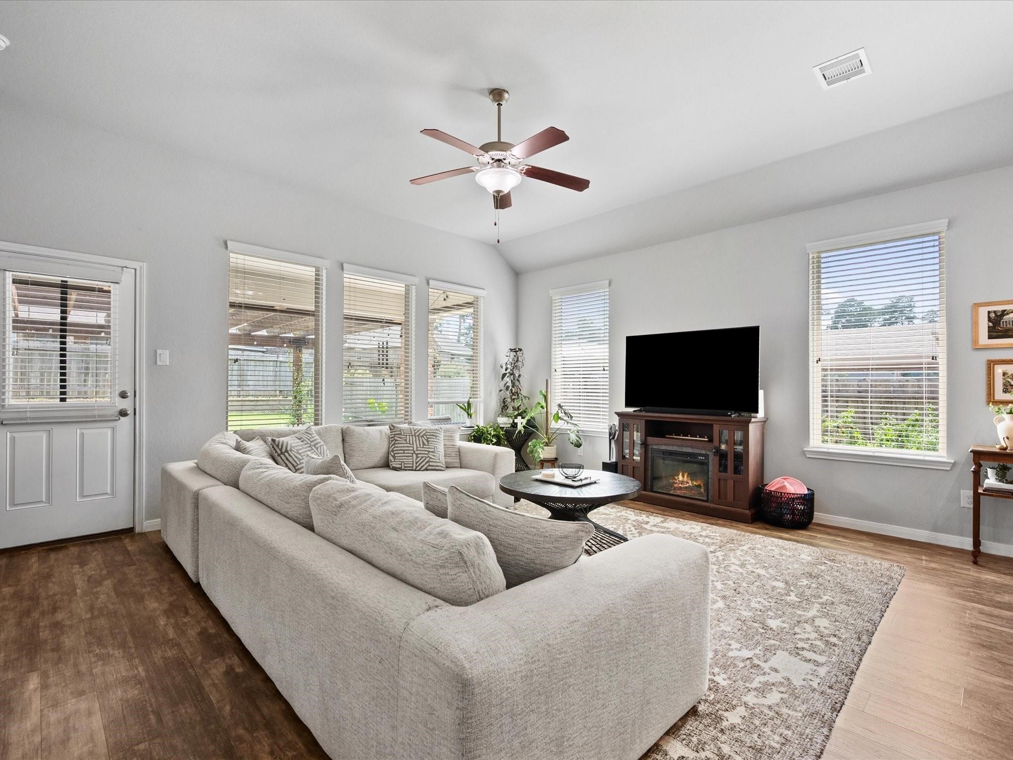 14381 Whitetop Peak Court Conroe, TX 77384 - Photo 10 of 39 a living room with furniture a flat screen tv and a large window