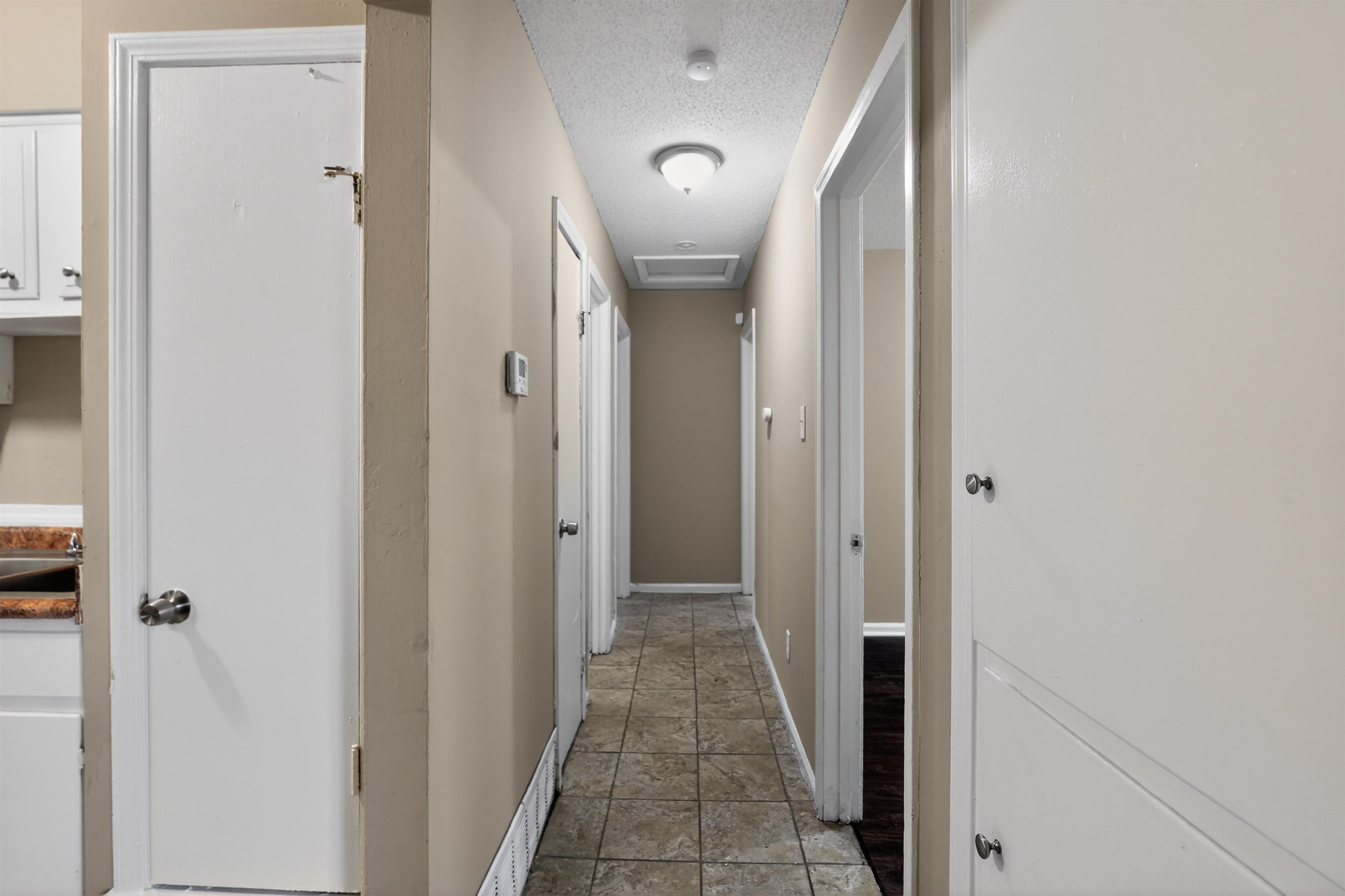 3608 Cane Ridge Drive Memphis, TN 38109 - Photo 29 of 31 Hallway with neutral wall paint, ceiling-mounted lighting, and square tile flooring