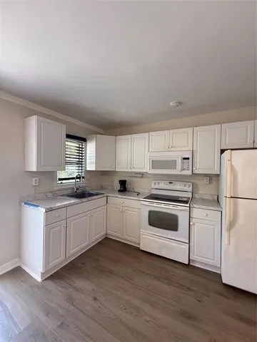 a kitchen with granite countertop white cabinets and white appliances