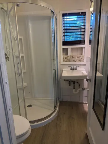 a bathroom with a sink a toilet and shower