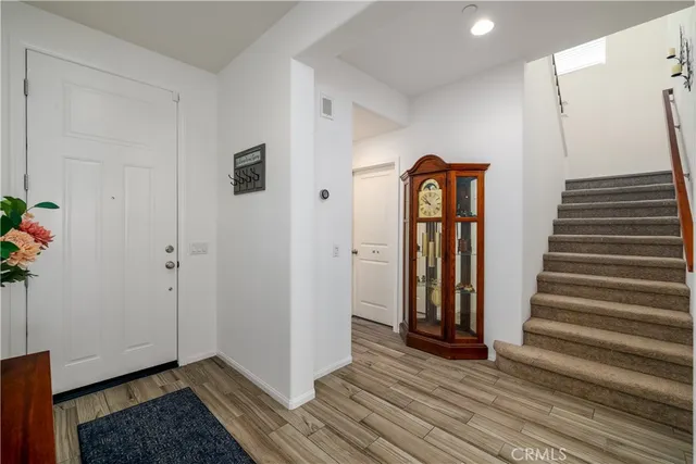 a view of a hallway with wooden floor and stairs