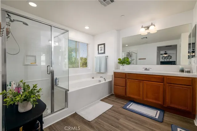 a spacious bathroom with a tub sink and mirror