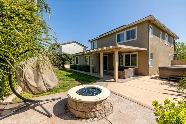 a view of a chair and table in backyard of the house