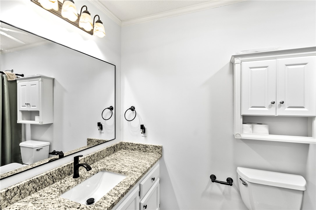 608 Robin Hood Lane Anderson, SC 29621 - Photo 17 of 36 Polished granite countertops and classic white cabinetry elevate this guest bathroom.