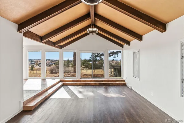 a view of a room with wooden floor and windows