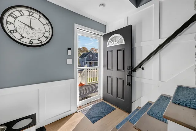 a view of a hallway with entryway wooden floor and front door