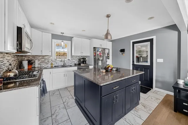 a kitchen with stainless steel appliances granite countertop a sink stove and refrigerator