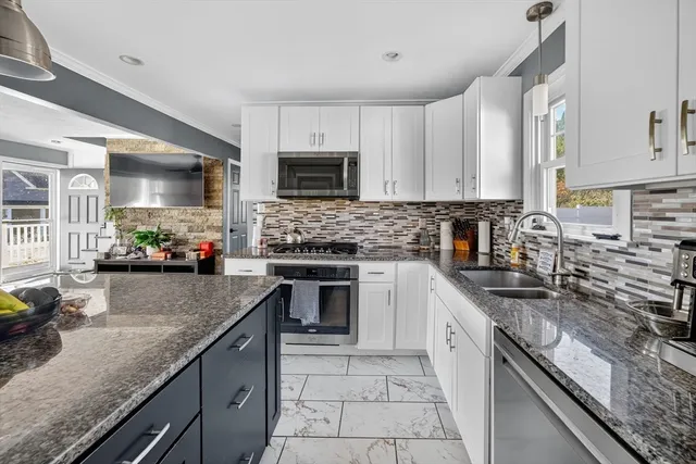 a kitchen with kitchen island granite countertop a sink counter top space appliances and cabinets