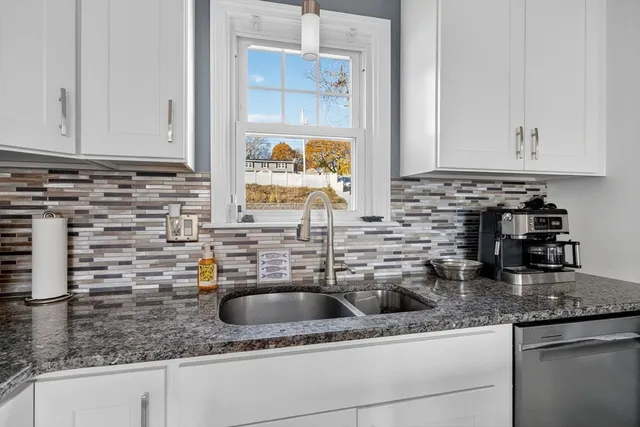 a kitchen with granite countertop a sink and a stove