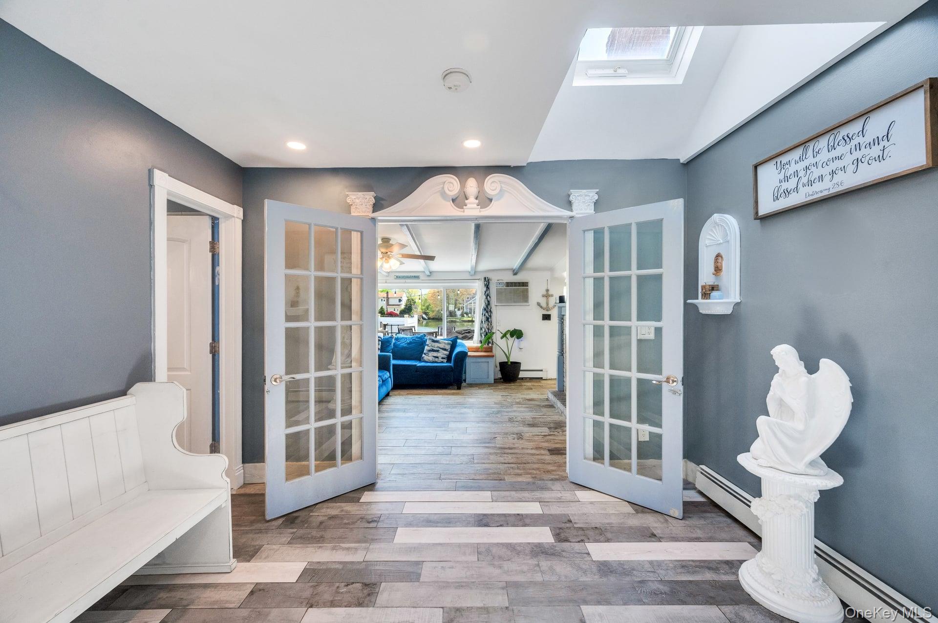 24 Raynor Street West Babylon, NY 11704 - Photo 13 of 45 Doorway to outside with wood finished floors, french doors, a baseboard radiator, recessed lighting, and beamed ceiling