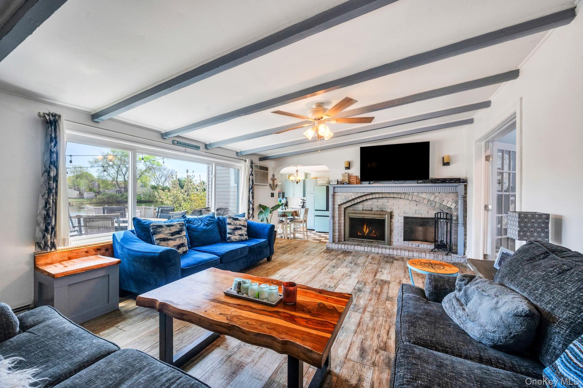 24 Raynor Street West Babylon, NY 11704 - Photo 15 of 45 Living room with a chandelier, wood finished floors, a fireplace, and a ceiling fan