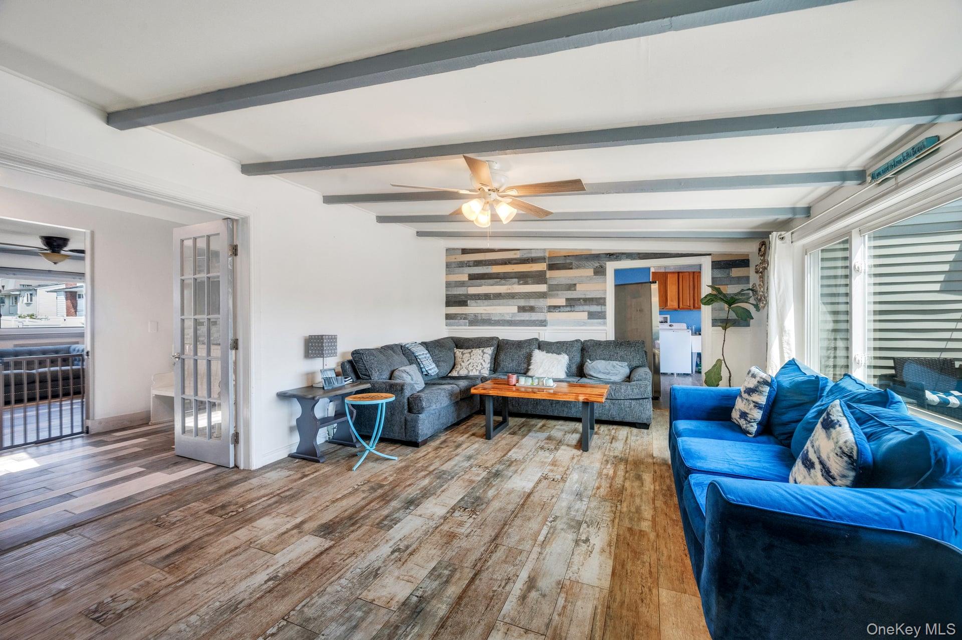 24 Raynor Street West Babylon, NY 11704 - Photo 17 of 45 Living room featuring a ceiling fan, wood finished floors, beamed ceiling, and washer / dryer