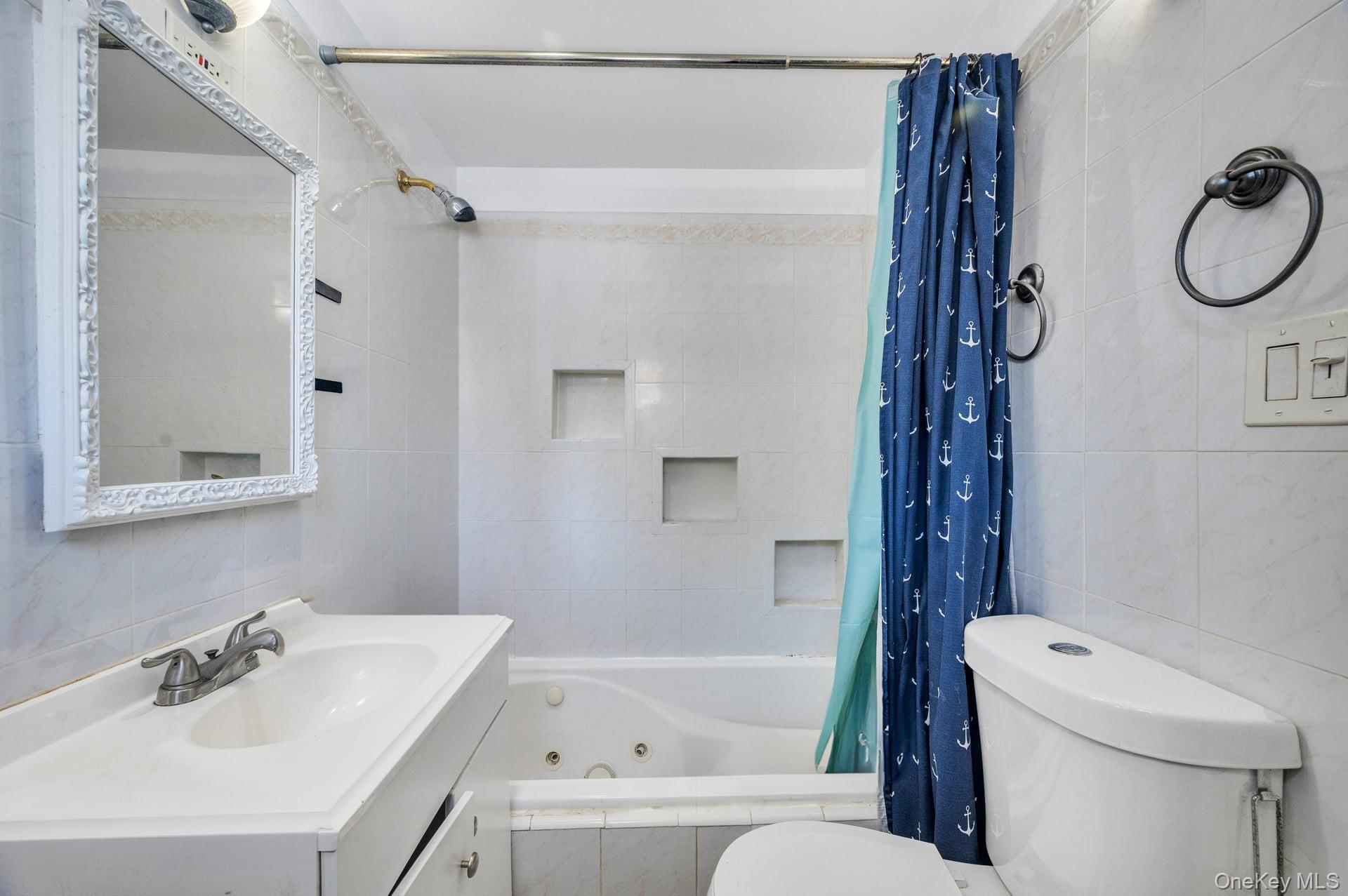 24 Raynor Street West Babylon, NY 11704 - Photo 20 of 45 Bathroom with tile walls, tiled shower / bath, vanity, and tasteful backsplash