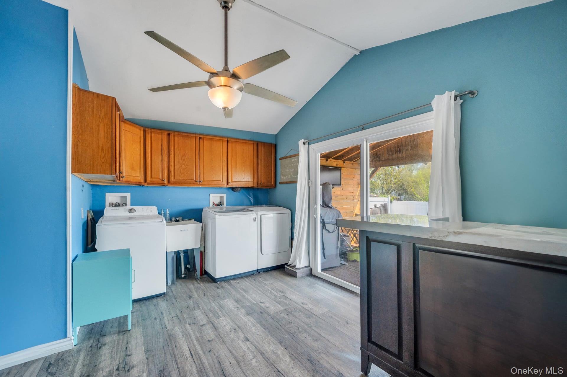 24 Raynor Street West Babylon, NY 11704 - Photo 21 of 45 Laundry room featuring cabinet space, washing machine and clothes dryer, light wood-style floors, and a ceiling fan