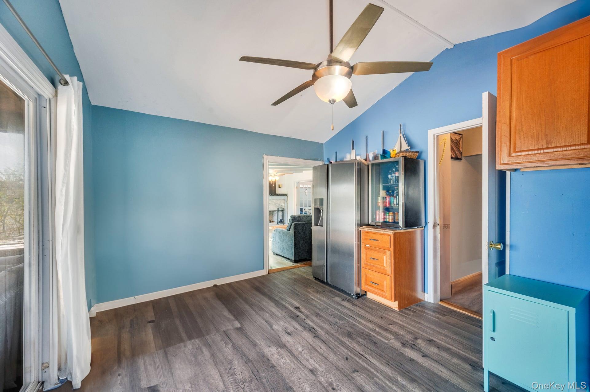 24 Raynor Street West Babylon, NY 11704 - Photo 23 of 45 Kitchen featuring lofted ceiling, dark wood-type flooring, a ceiling fan, and stainless steel refrigerator with ice dispenser