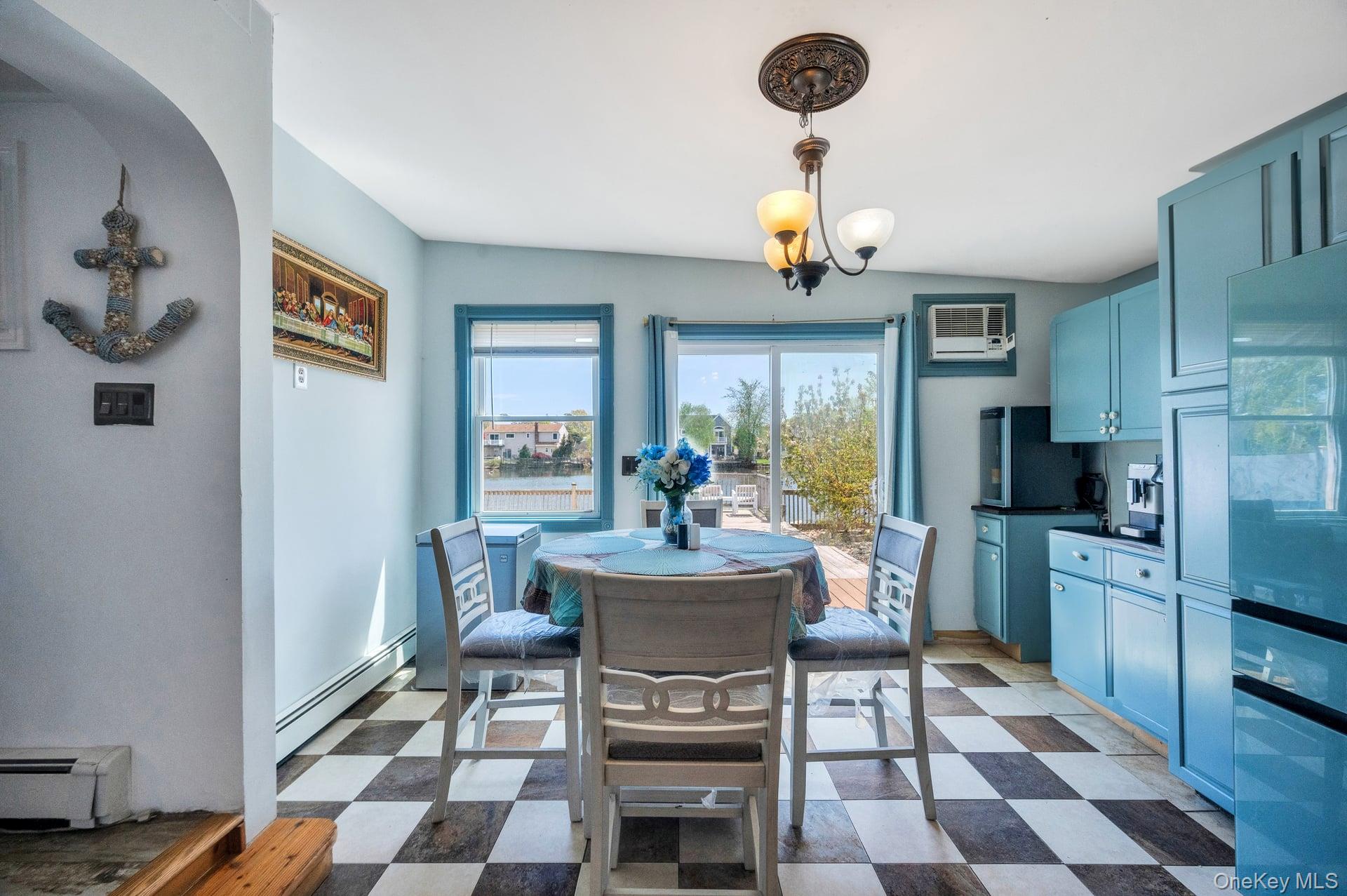 24 Raynor Street West Babylon, NY 11704 - Photo 25 of 45 Dining area featuring dark flooring, baseboard heating, and a chandelier