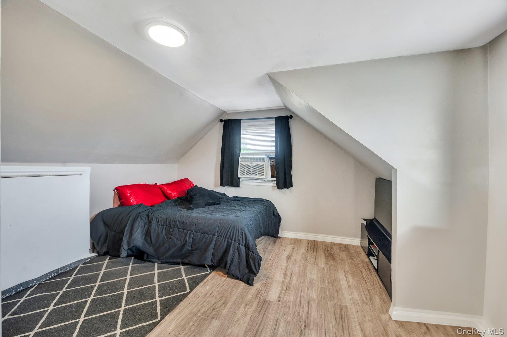 24 Raynor Street West Babylon, NY 11704 - Photo 33 of 45 Bedroom featuring light wood-type flooring, lofted ceiling, and cooling unit