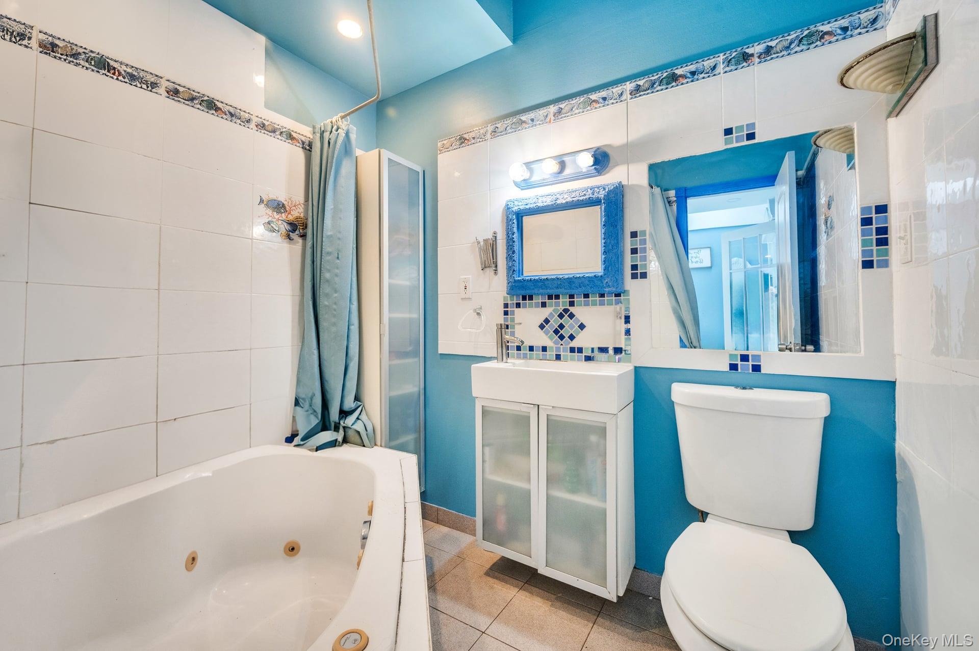 24 Raynor Street West Babylon, NY 11704 - Photo 38 of 45 Bathroom with tile patterned flooring, tile walls, and vanity