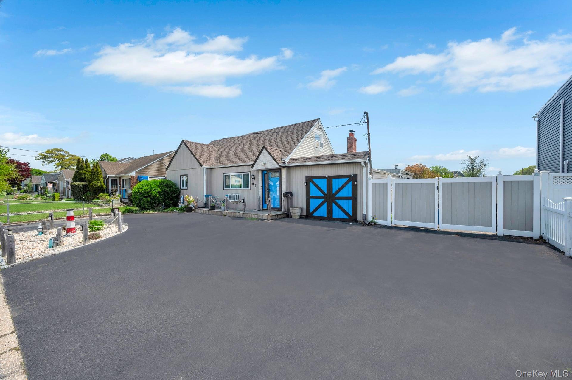 24 Raynor Street West Babylon, NY 11704 - Photo 4 of 45 View of front facade featuring a chimney, a gate, and driveway