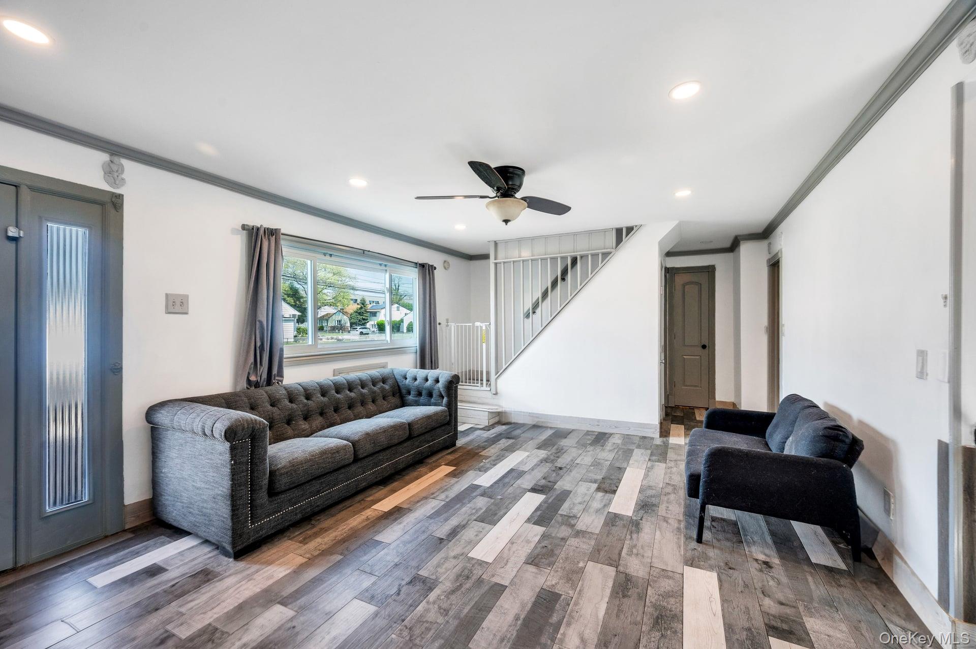 24 Raynor Street West Babylon, NY 11704 - Photo 10 of 45 Living area with crown molding, wood finished floors, recessed lighting, and ceiling fan
