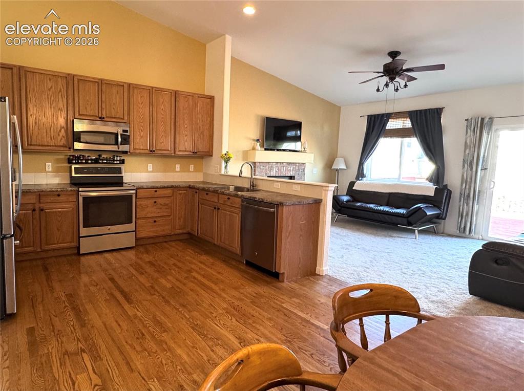9362 St.George Road Peyton, CO 80831 - Photo 5 of 32 a kitchen with stainless steel appliances granite countertop a sink dishwasher stove top oven and cabinets with wooden floor