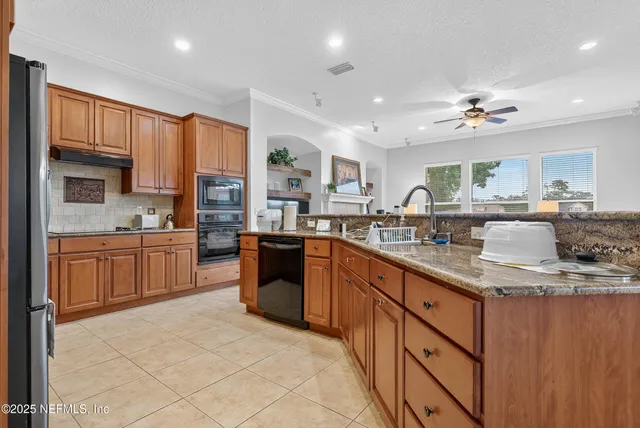 a kitchen with kitchen island granite countertop a sink counter top space appliances and cabinets