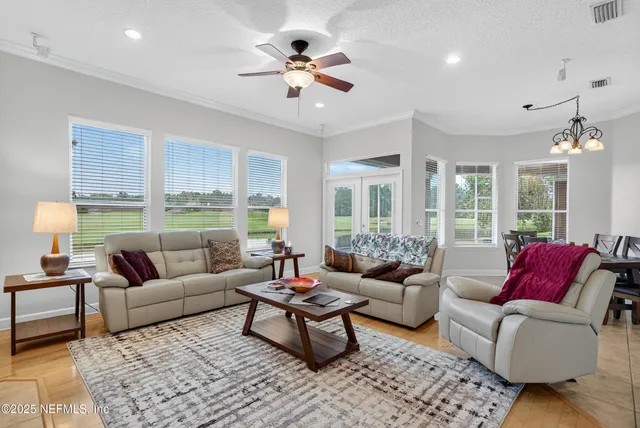 a living room with furniture ceiling fan and a large window
