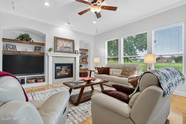 a living room with furniture a large window and a flat screen tv