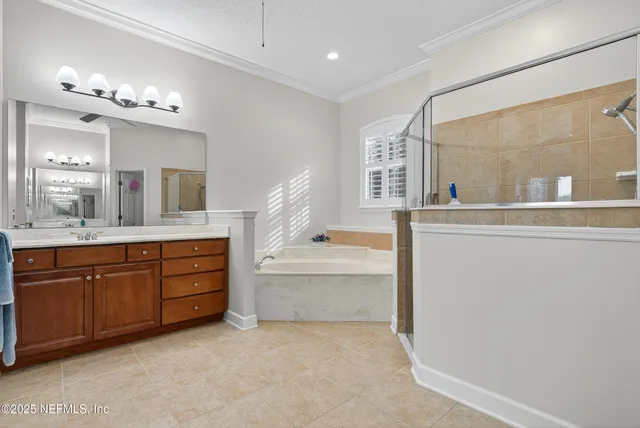 a spacious bathroom with a tub sink and mirror