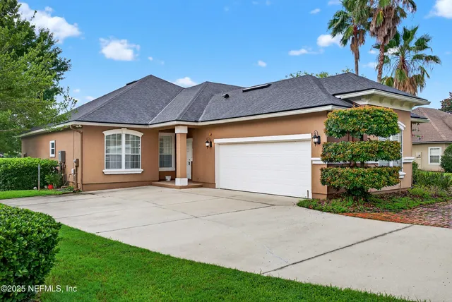 a front view of a house with a garden and yard