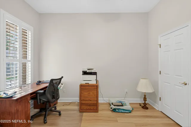 a view of a workspace with furniture and a window