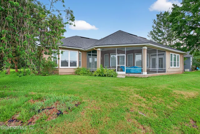 a front view of a house with a yard and potted plants
