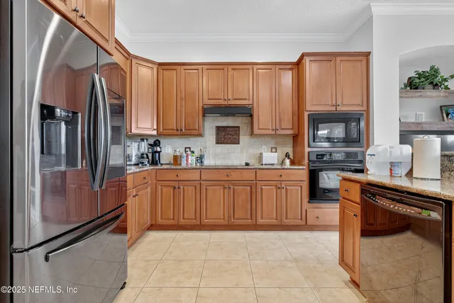 a kitchen with stainless steel appliances granite countertop a refrigerator stove top oven and sink