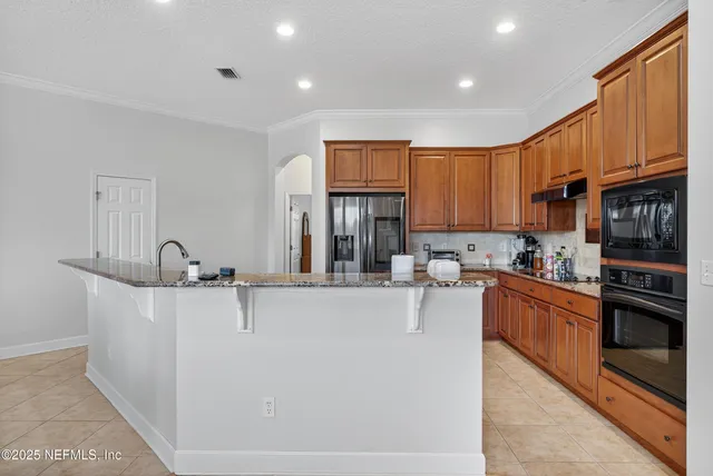 a large kitchen with stainless steel appliances granite countertop a stove and a sink