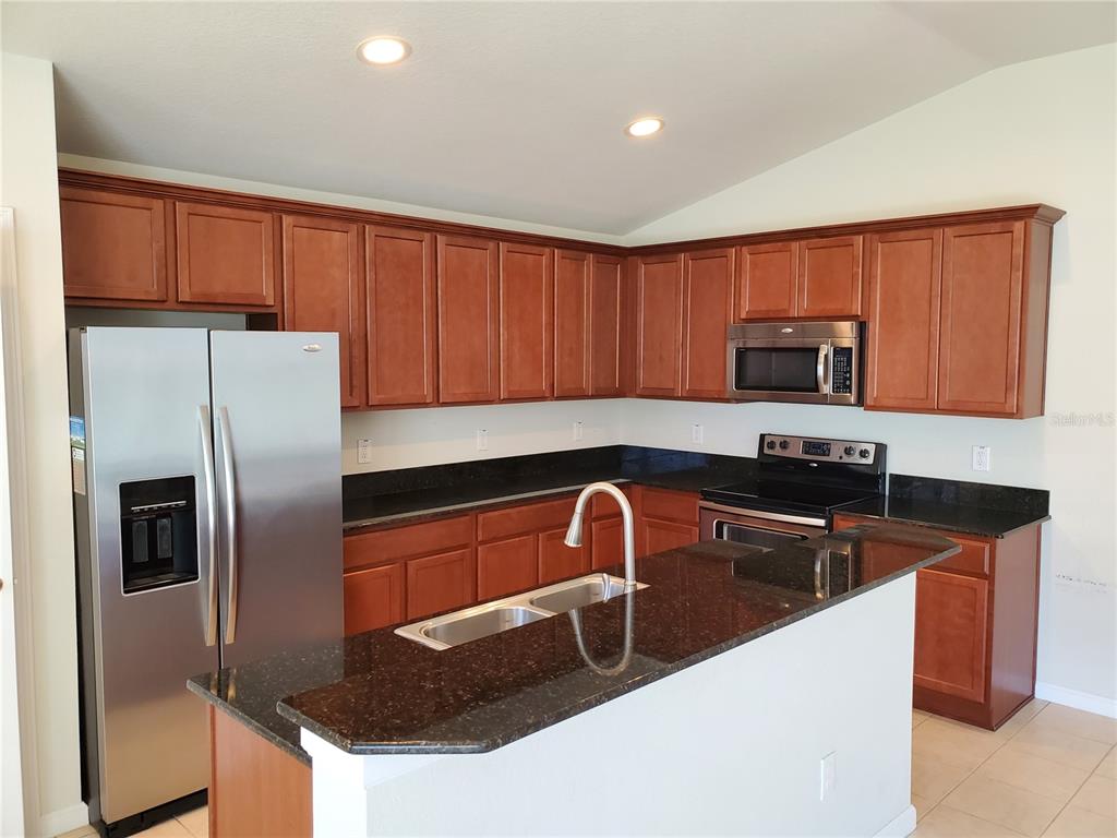 4079 Southwest 47th Court Ocala, FL 34474 - Photo 2 of 31 a kitchen with stainless steel appliances granite countertop a sink stove and refrigerator