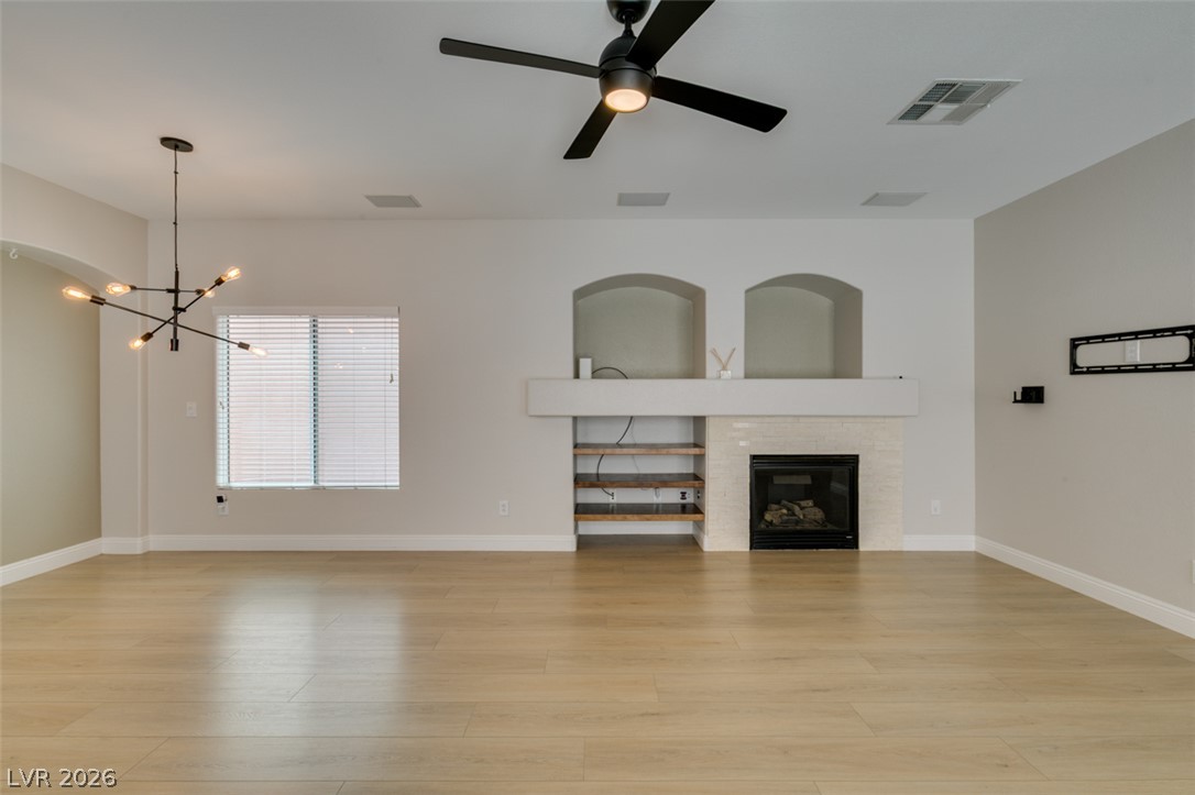 8909 Houston Ridge Avenue Las Vegas, NV 89178 - Photo 5 of 45 A warm, naturally illuminated living space features sleek wood flooring and a contemporary fireplace.