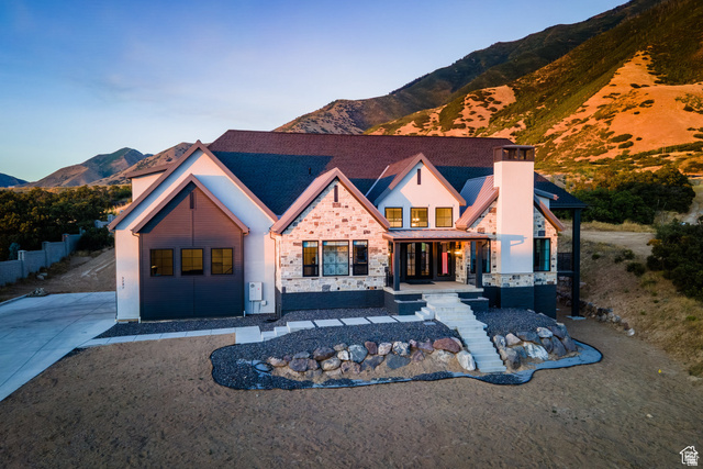 3247 South Mapleton Estates Drive Mapleton, UT 84664 - Photo 60 of 70 View of front facade with a mountain view, a porch, stone siding, and a chimney