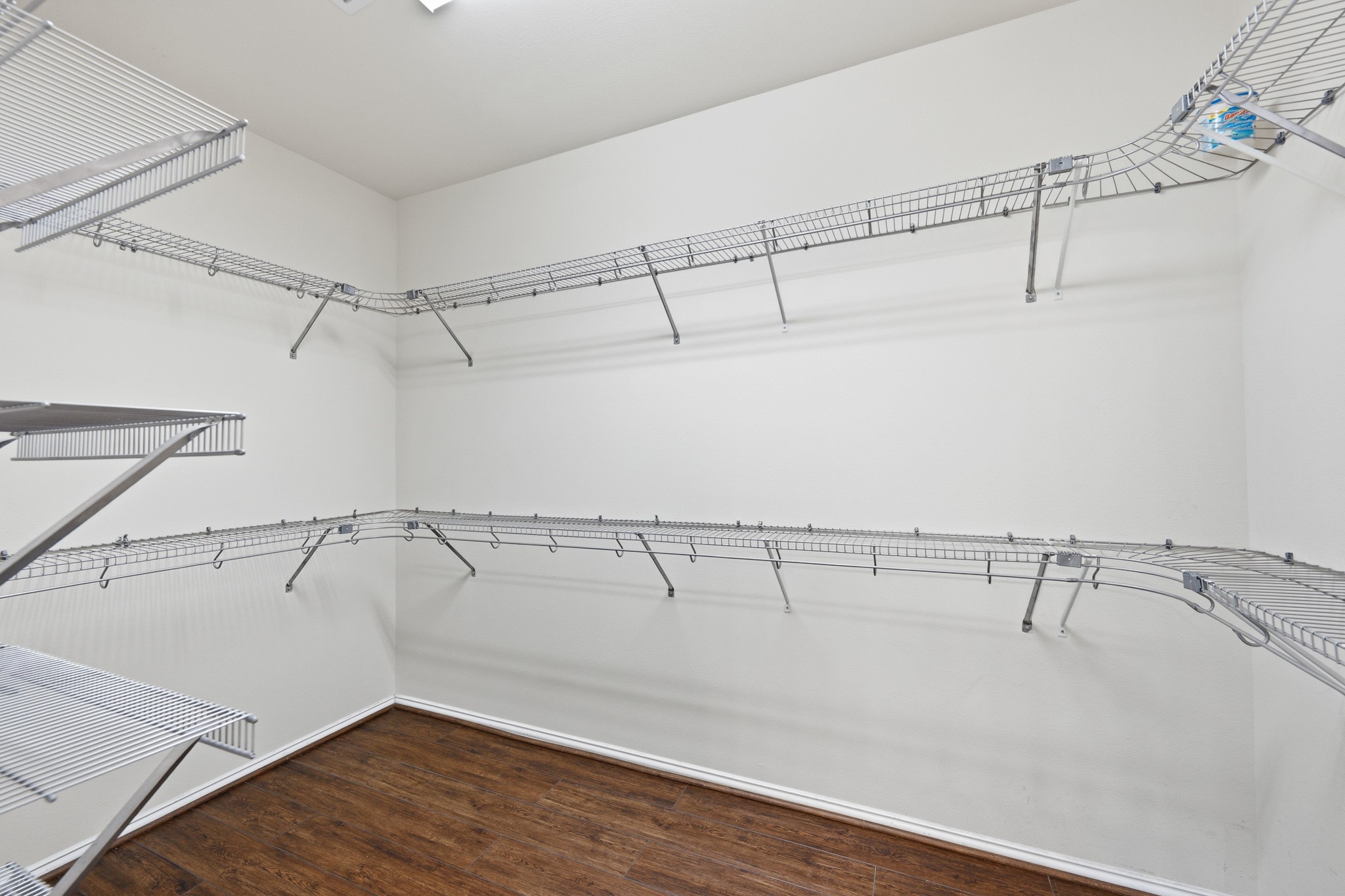 2117 Rushing Spring Drive Pearland, TX 77584 - Photo 26 of 42 Experience ultimate organization in the spacious primary closet, featuring sleek wire shelving and elegant flooring for a stylish, functional retreat.