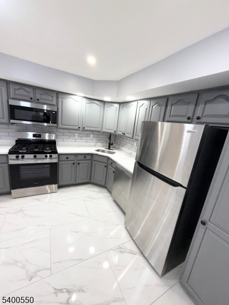 68 Marrow Street Newark, NJ 07103 - Photo 3 of 17 a kitchen with stainless steel appliances a refrigerator sink and stove