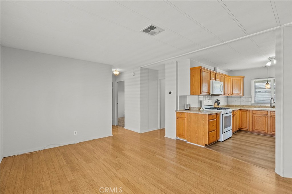 6480 Katherine, Unit 75 Simi Valley, CA 93063 - Photo 17 of 30 a large white kitchen with kitchen island a sink wooden floor and counter top space