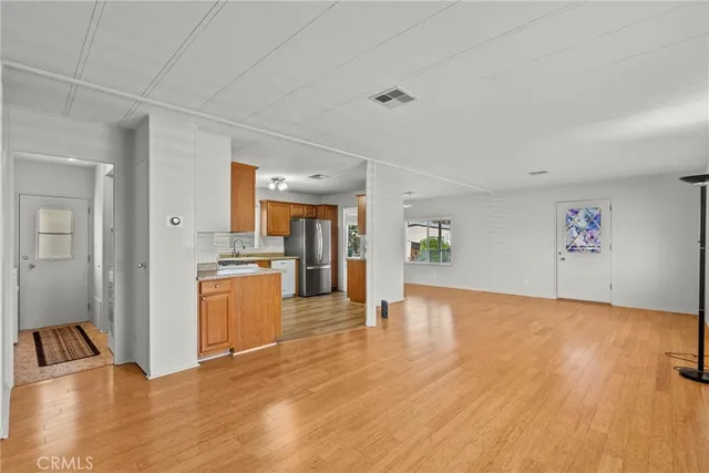 a kitchen with stainless steel appliances granite countertop a sink cabinets and wooden floor