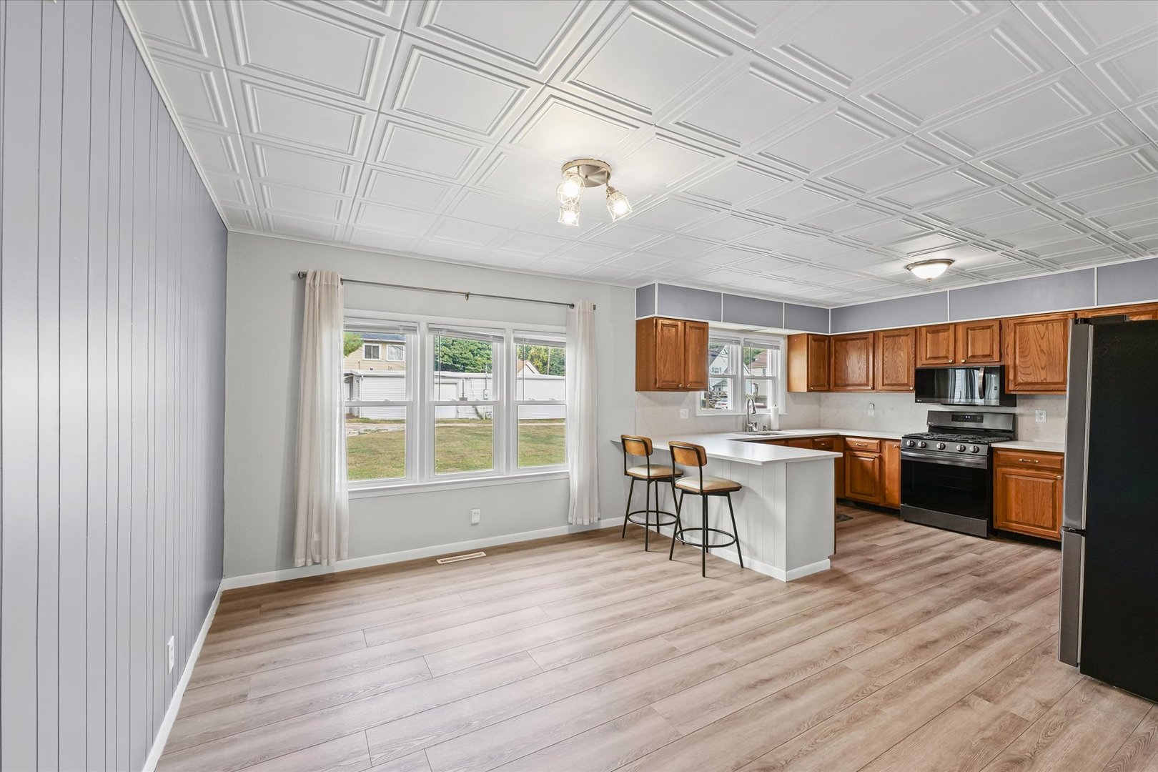 601 West Main Street Clinton, IL 61727 - Photo 12 of 33 a kitchen with stainless steel appliances granite countertop a stove top oven a sink dishwasher a dining table and chairs with wooden floor