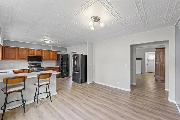a open kitchen with stainless steel appliances granite countertop a refrigerator and a stove top oven