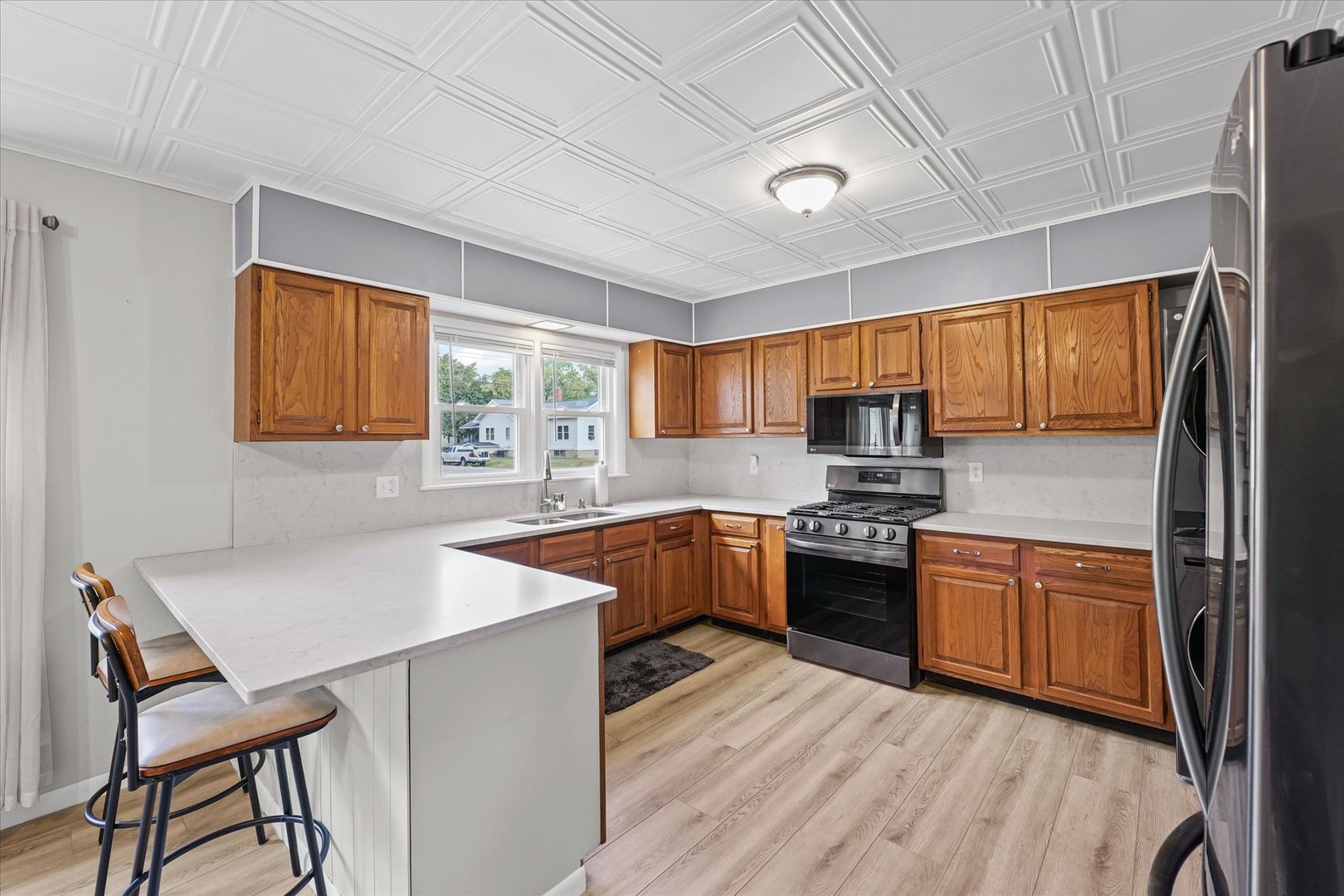 601 West Main Street Clinton, IL 61727 - Photo 14 of 33 a kitchen with stainless steel appliances granite countertop wooden cabinets a sink dishwasher a stove and a refrigerator with wooden floor