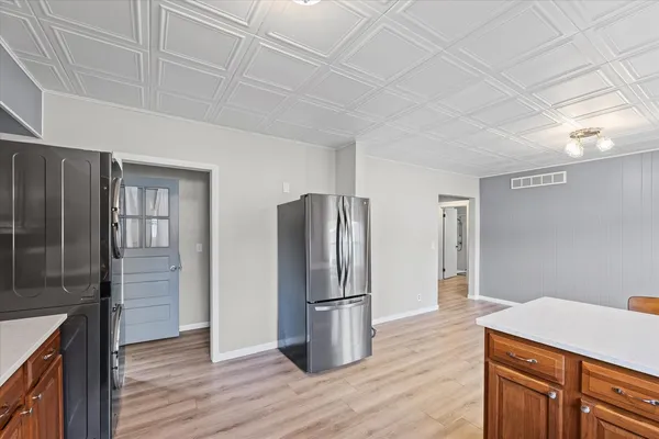 a kitchen with stainless steel appliances granite countertop a refrigerator and a stove top oven